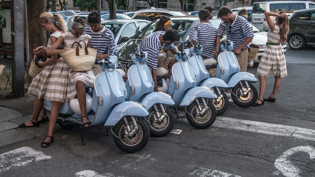 Vespa-skootteri ja ihmisiä kaupunkimiljöössä
