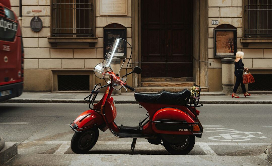 Punainen Vespa-skootteri pysäköitynä tien varteen